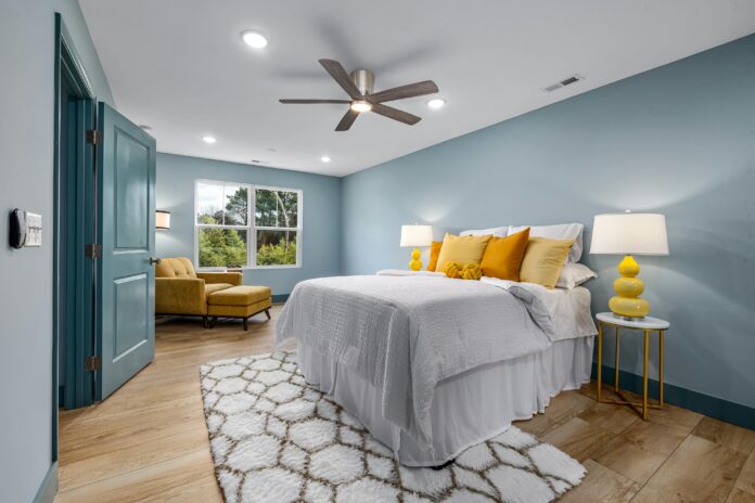 Cozy bedroom design with soft lighting, warm textiles, and layered bedding, featuring a comfortable bed, throw blankets, pillows, and a calm, inviting atmosphere.