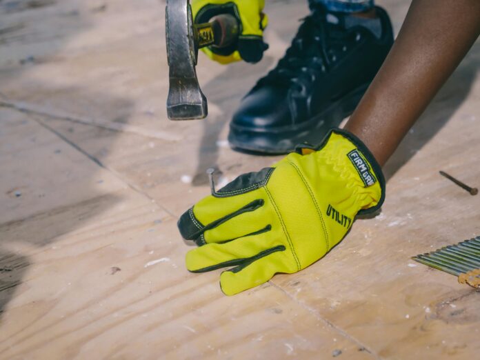 Close-up of repairing flooring scratches on a wooden surface using a filler and a soft cloth for a smooth finish.