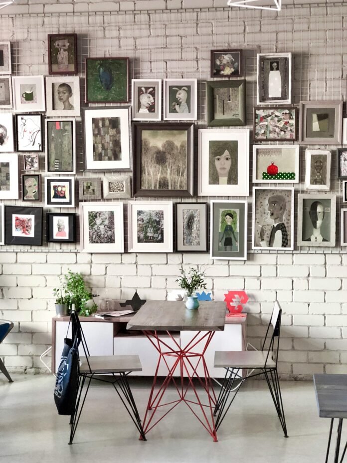 A stylish gallery wall design showcasing an arrangement of framed artwork, photos, and decorative pieces in various sizes for a modern living room.