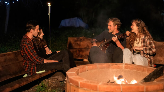 A beautifully designed backyard fire pit surrounded by seating, featuring stylish landscaping elements and ambient lighting for a cozy outdoor atmosphere.