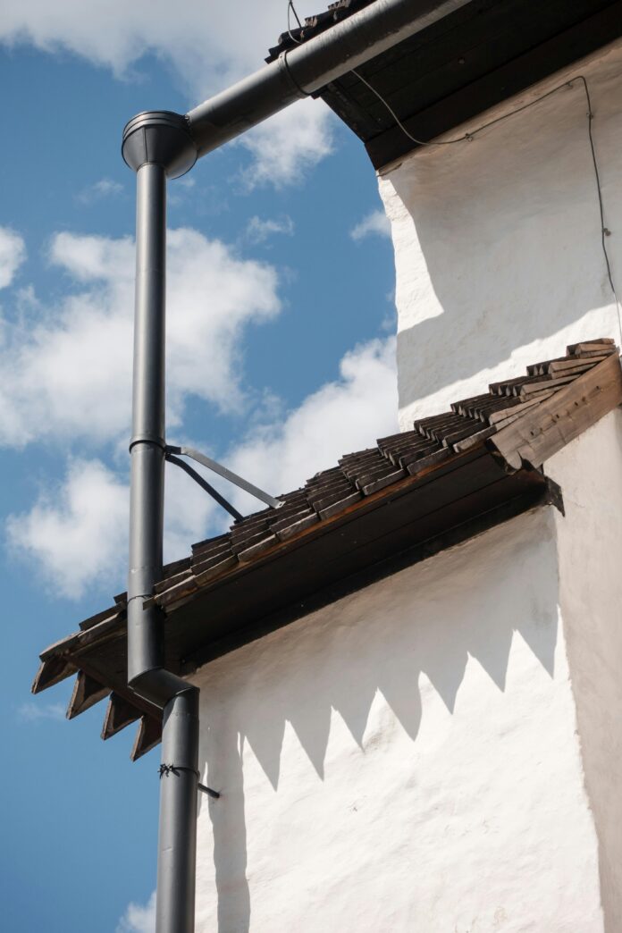 A professional installing gutter guards on a residential roof to prevent clogging.