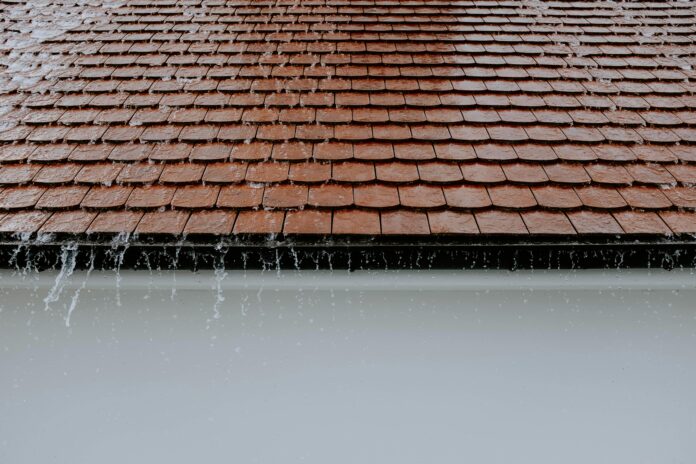 durable gutter system designed for heavy rain, featuring wide downspouts and reinforced gutter guards to handle large water volumes.